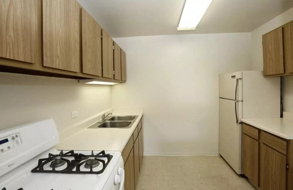 an empty kitchen with a stove and a refrigerator