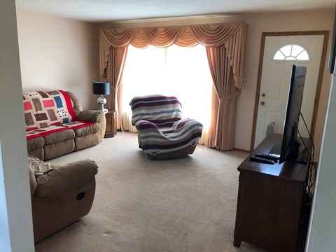 A living room with a striped chair in the middle.