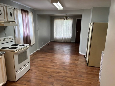 a kitchen and a hallway with a stove and a refrigerator