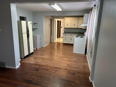 a kitchen with a hard wood floor and a refrigerator