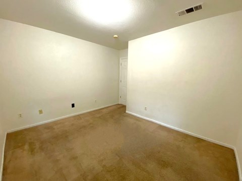 a empty living room with white walls and carpet