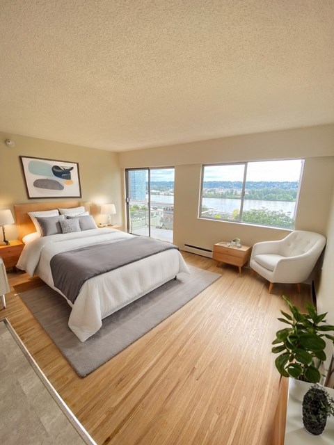 A bedroom with a large bed and a view of the city.