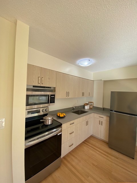 A kitchen with wooden floors and stainless steel appliances.