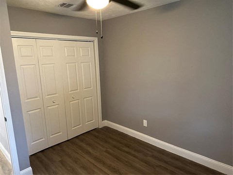 a bedroom with two closets and a wood floor