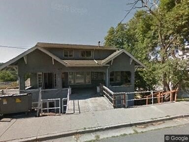 a train station with a porch and a fence