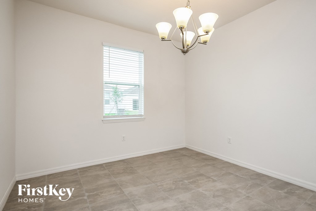 the living room of a home with white walls and a window