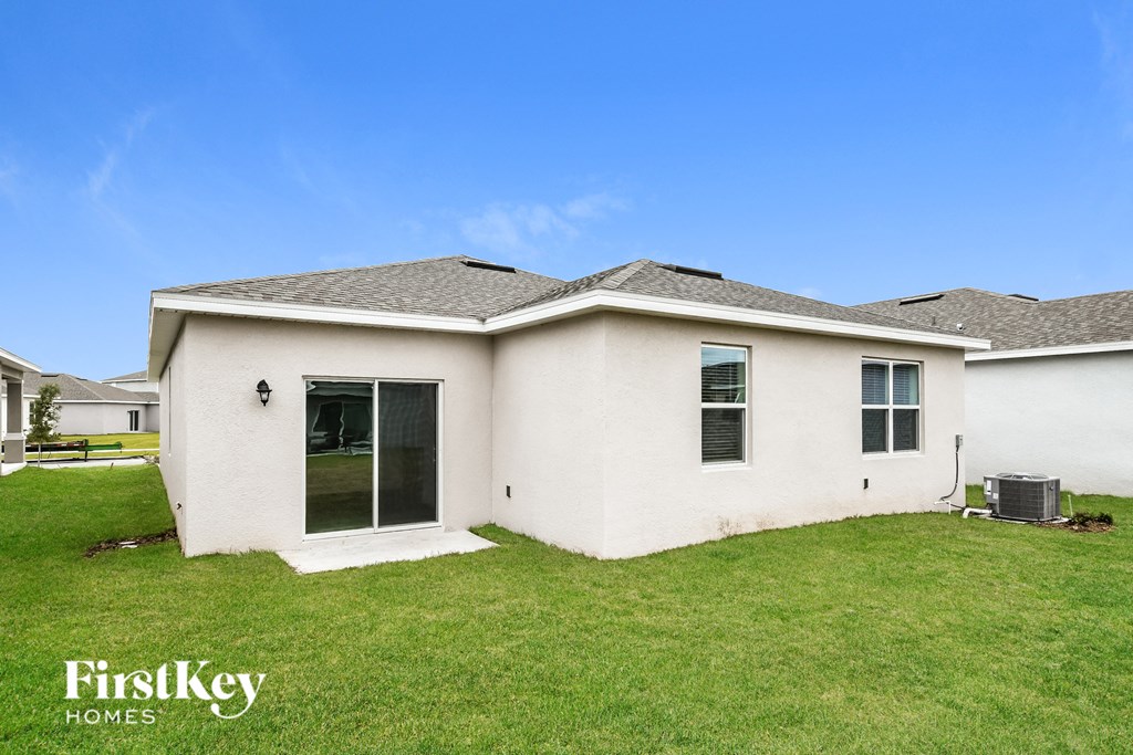 a white house with a green lawn and a blue sky