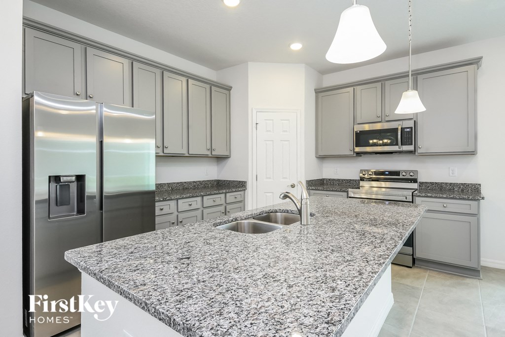A kitchen with granite countertops and stainless steel appliances.