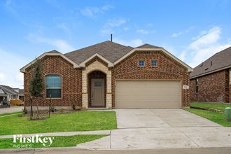 front view of a brick house with a garage and a driveway