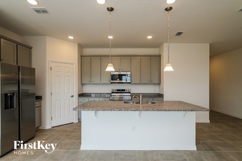 a kitchen with white cabinets and a granite counter top