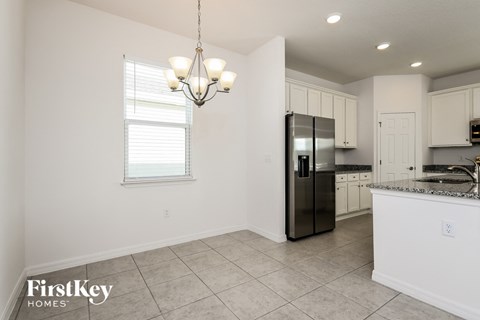 a kitchen with white cabinets and a stainless steel refrigerator