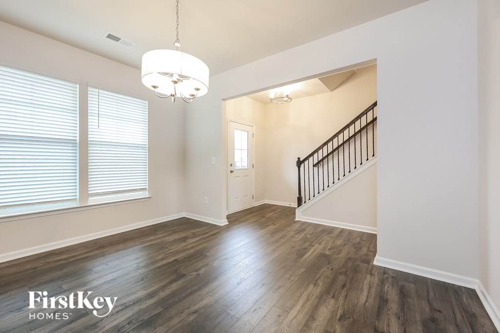an empty living room with wood floors and a staircase