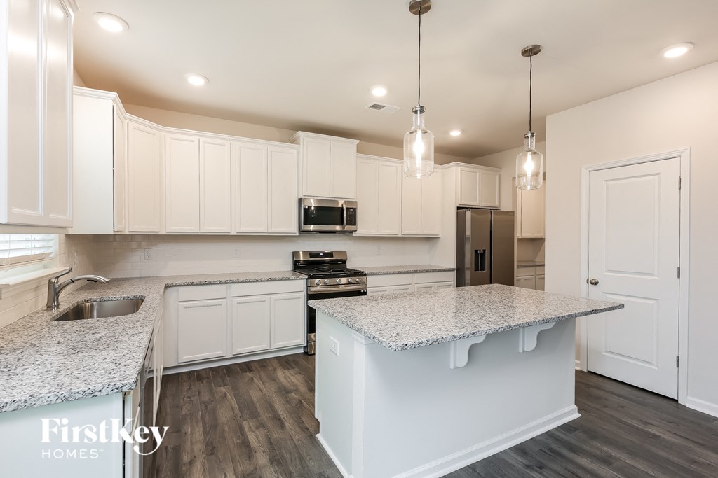 a kitchen with white cabinets and granite counter tops
