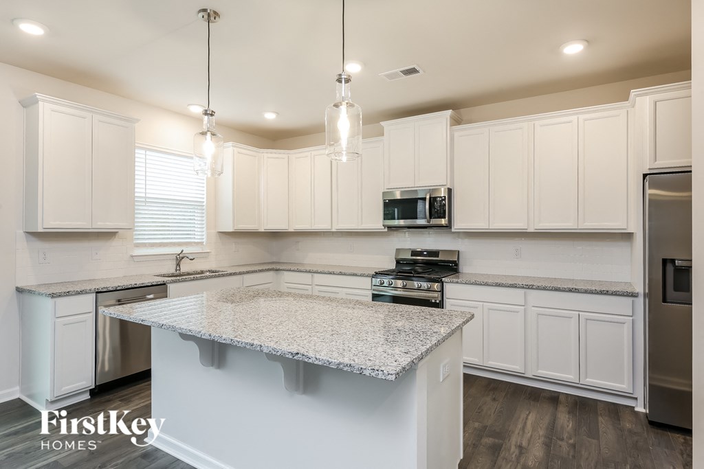 a white kitchen with marble counter tops and white cabinets