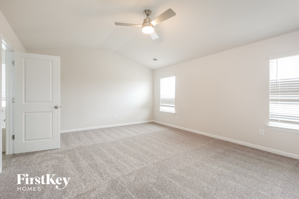a spacious living room with a ceiling fan and a window