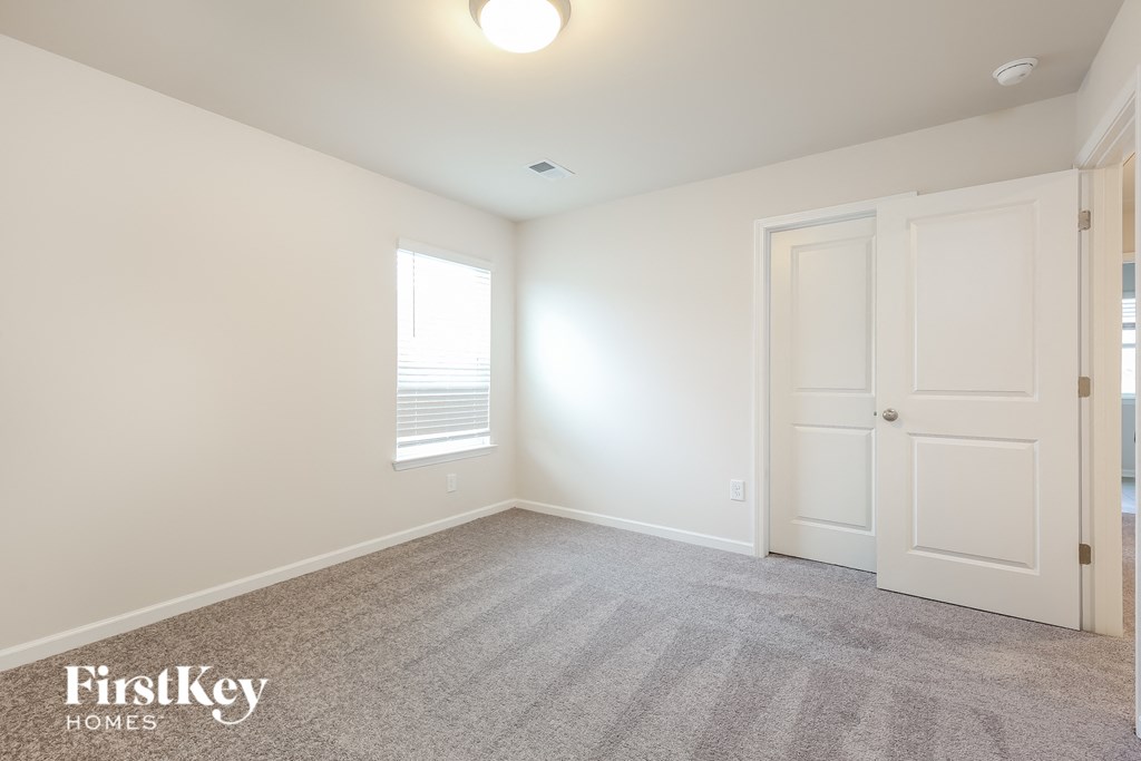 a bedroom with a carpeted floor and white doors