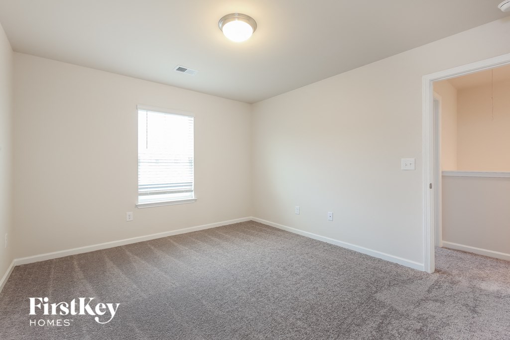 a bedroom with a carpeted floor and a window