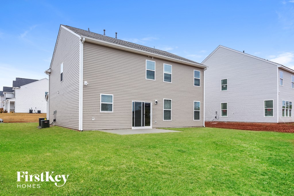 a white house with gray siding and a green lawn