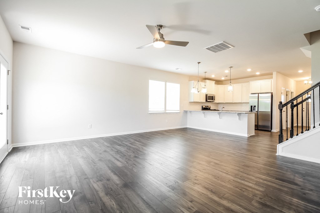 an empty living room with white walls and wood floors