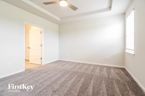 a living room with carpet and a ceiling fan