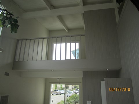 A balcony with a window and a view of the street below.