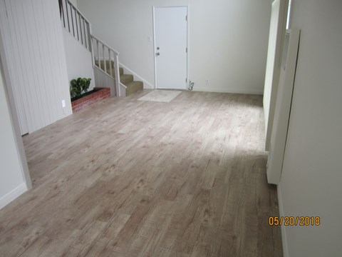 A room with a wooden floor and a white door.