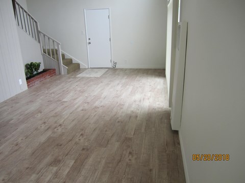 A room with a wooden floor and a white door.