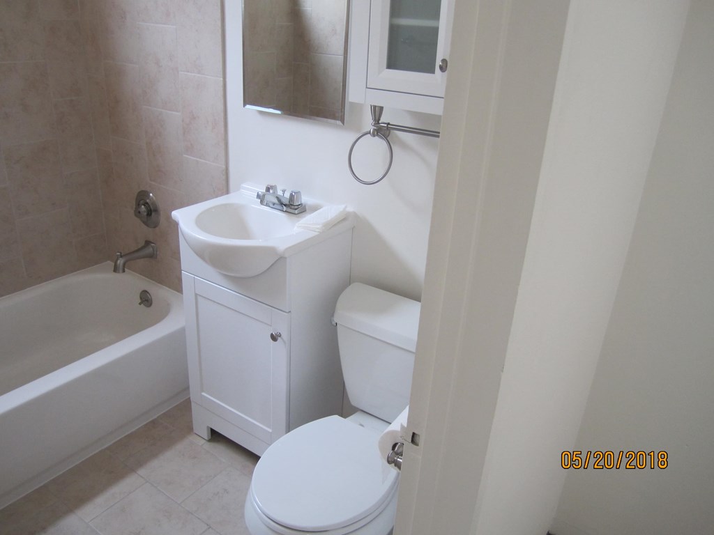 A white bathroom with a toilet, sink, and bathtub.