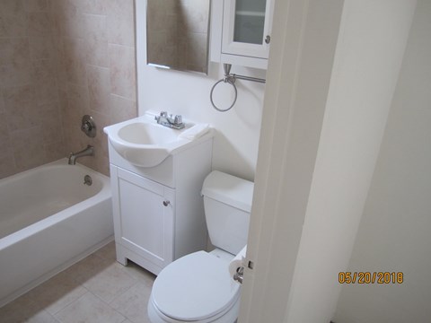 A white bathroom with a toilet, sink, and bathtub.