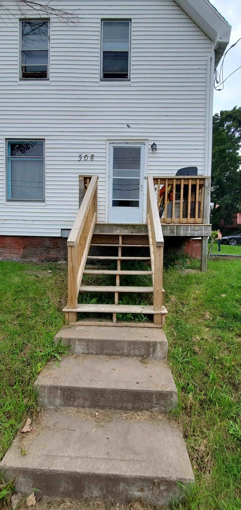 a house with a wooden porch and stairs in front of it