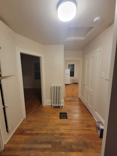 a living room with a wood floor and a white radiator