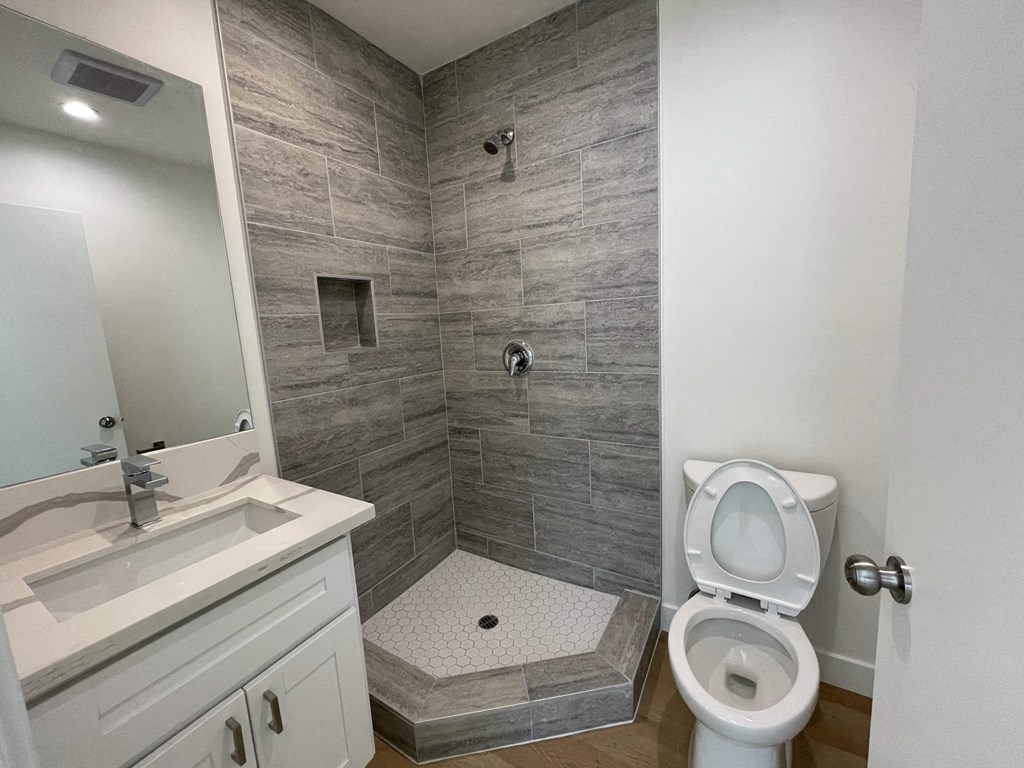 a bathroom with a shower and a toilet and a sink