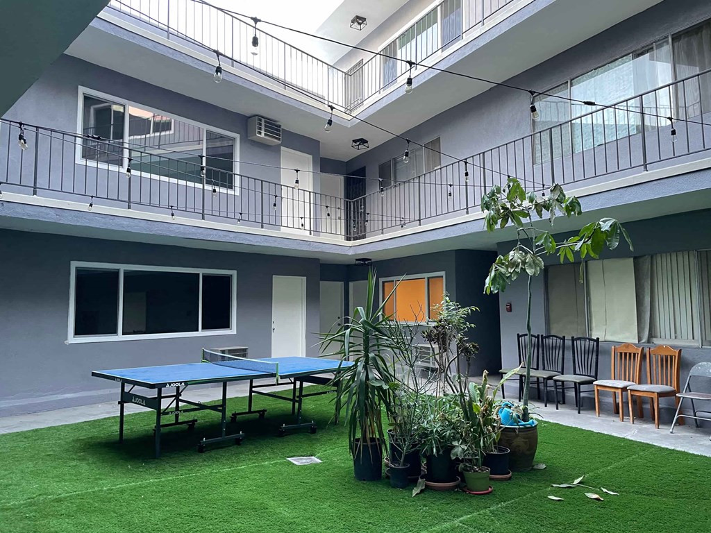 a room with a ping pong table and plants