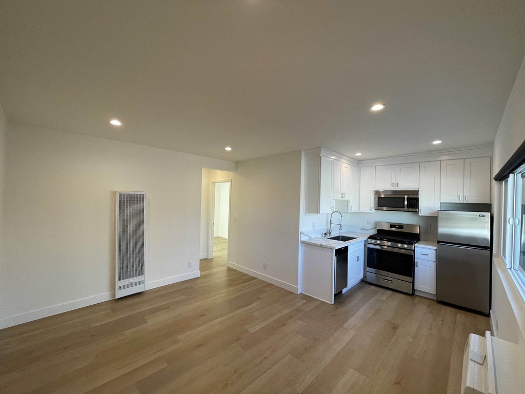 a renovated kitchen with white cabinets and stainless steel appliances