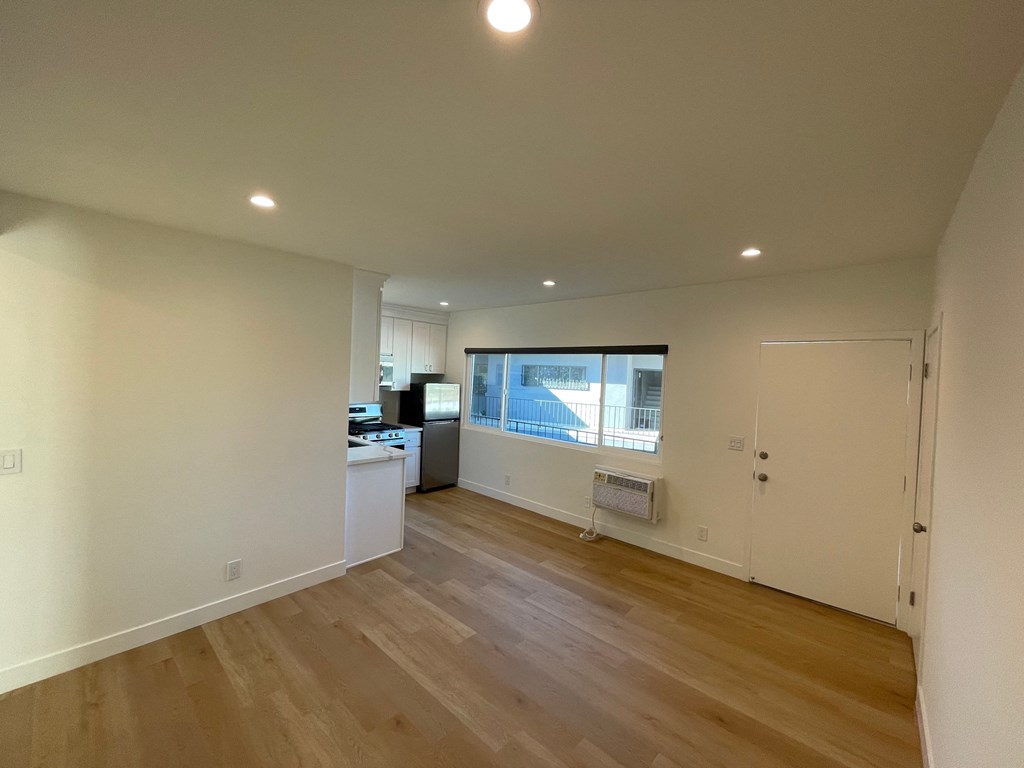 a kitchen and living room with wood floors and white walls