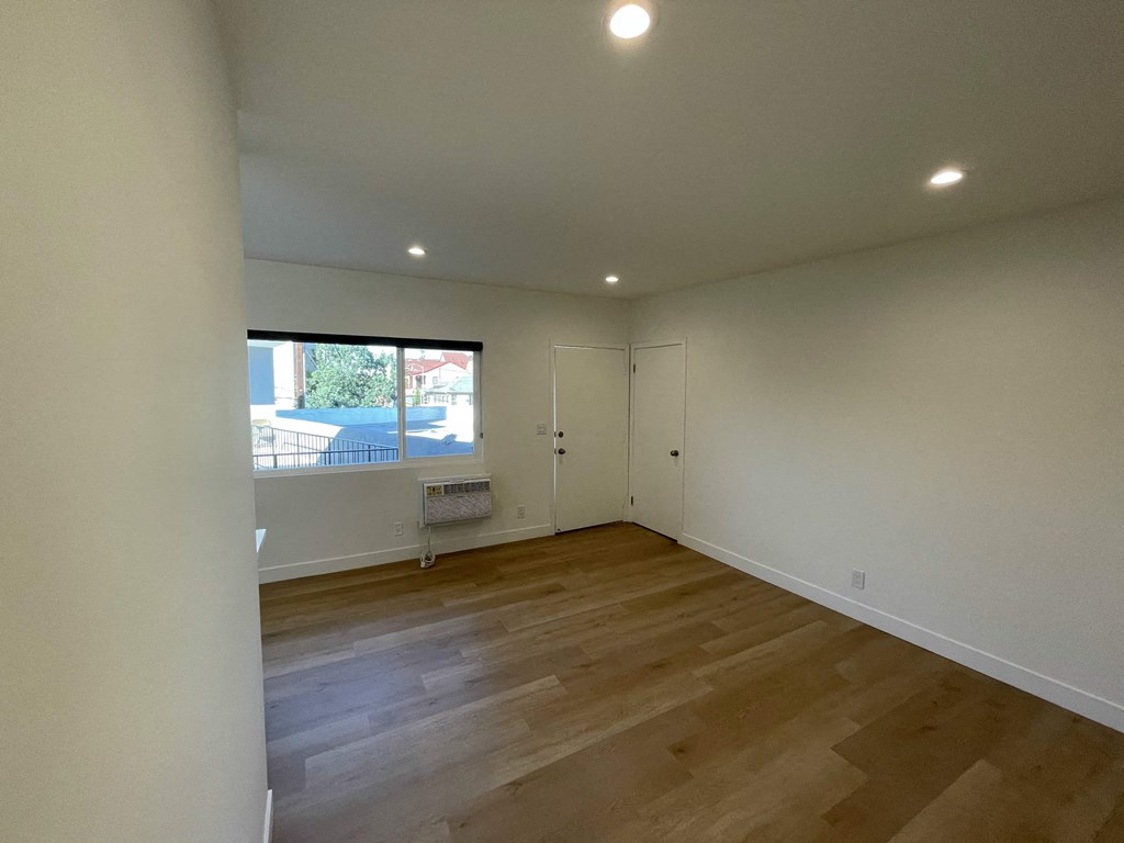 a living room with wooden floors and a window