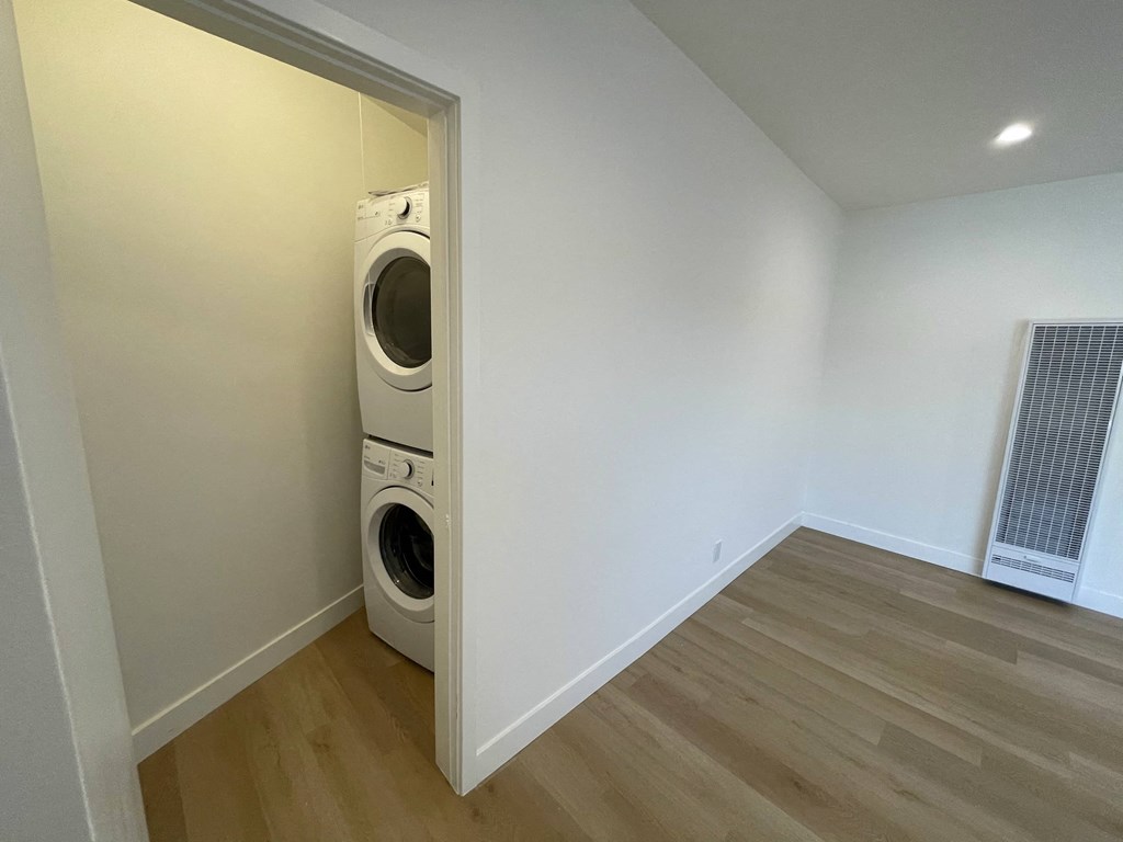 a laundry room with a washer and dryer in a white wall