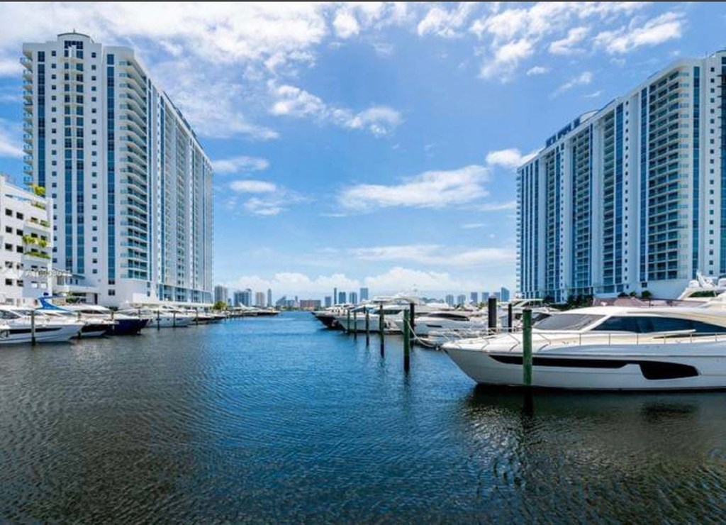 a harbor filled with boats next to tall buildings