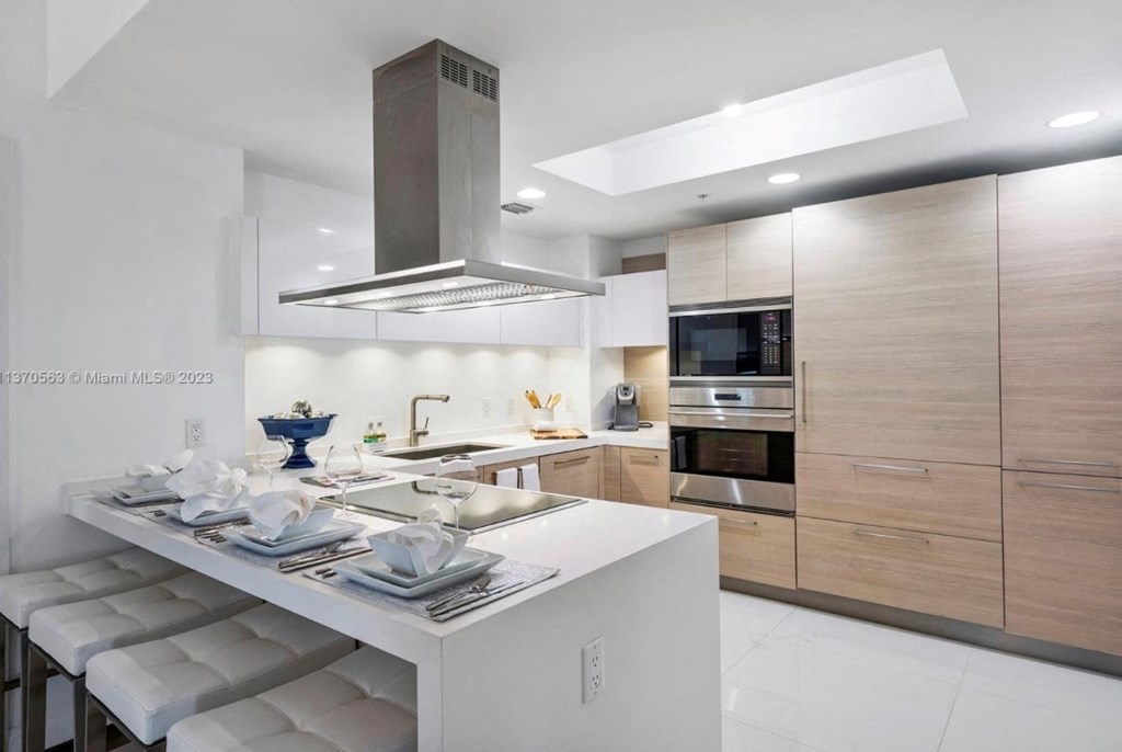 a modern kitchen with a white island and wooden cabinets
