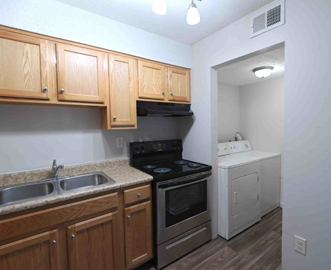 A kitchen with wooden cabinets and a black stove top oven.