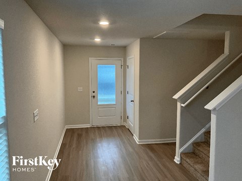 a hallway with a white door and stairs and a door to the beach