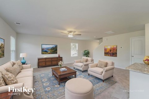 A living room with a white couch, a coffee table, and a painting on the wall.