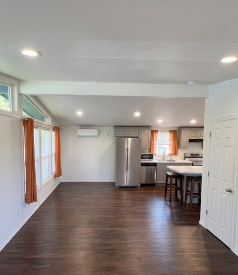 A kitchen with a refrigerator, oven, and sink.