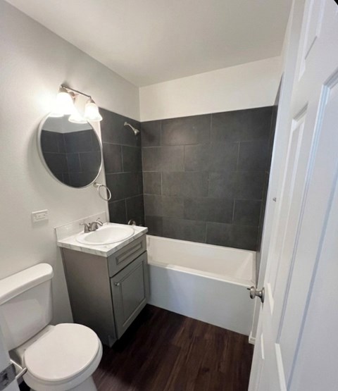 A bathroom with a toilet, sink, and bathtub.