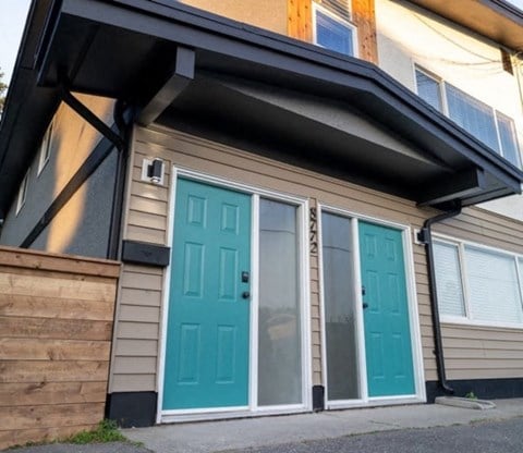 the front of a house with two blue doors