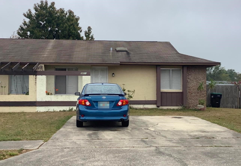 a blue car parked in front of a house