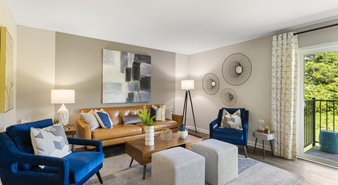 A living room with blue chairs and a painting on the wall.