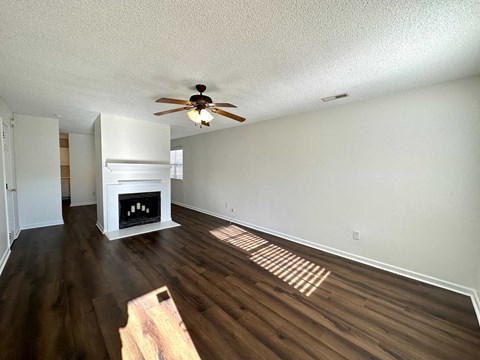 a living room with a fireplace and a ceiling fan