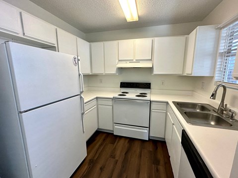 a kitchen with white cabinets and a sink and a refrigerator