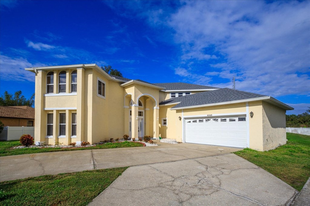 A two-story house with a garage on the right side.